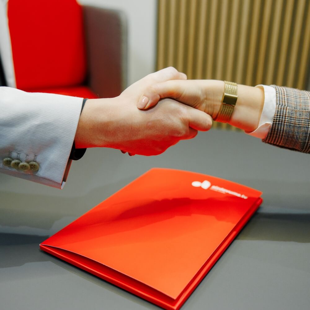 Sadarbības partneris paspiež roku Aizdevums.lv darbiniekam par noslēgto līgumu.