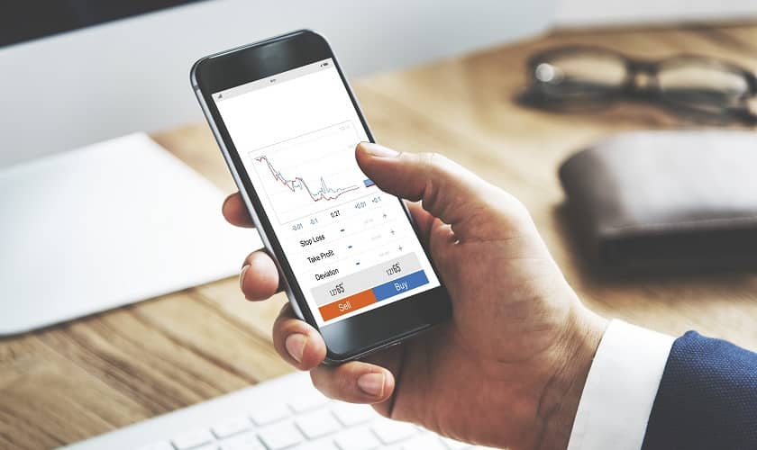 Investors lieto finanšu aplikāciju, lai apskatīto iespējas, kur ieguldīt naudu. Investors lieto finanšu aplikāciju, lai apskatīto iespējas, kur ieguldīt naudu.