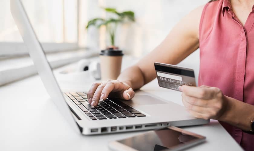 Sieviete veic drošus pirkumus internetā ar bankas karti. Sieviete veic drošus pirkumus internetā ar bankas karti.