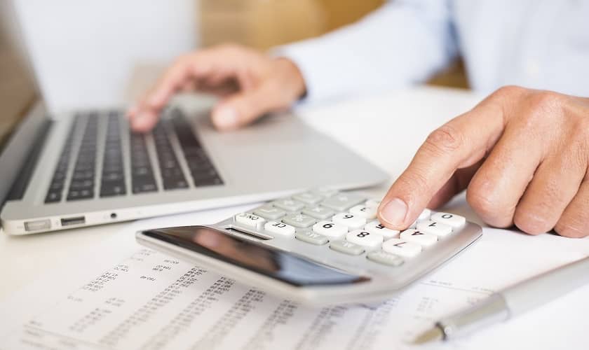 Vīrietis veic personīgo finanšu plānošanu ar datora un kalkulatora palīdzību. Vīrietis veic personīgo finanšu plānošanu ar datora un kalkulatora palīdzību.